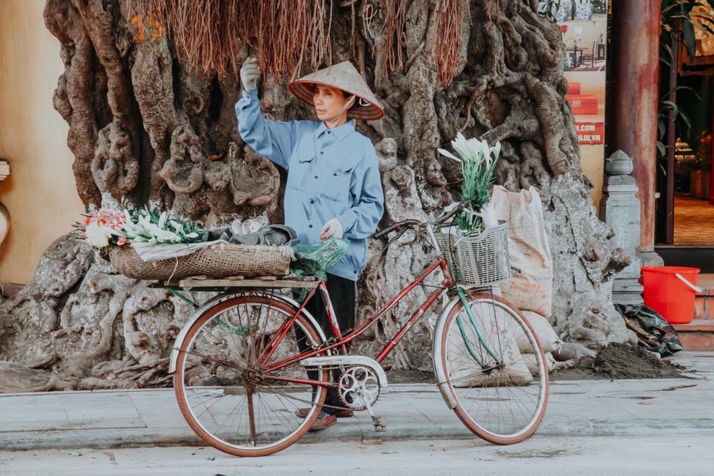 Eine Blumenverkäuferin in der Altstadt von Hanoi