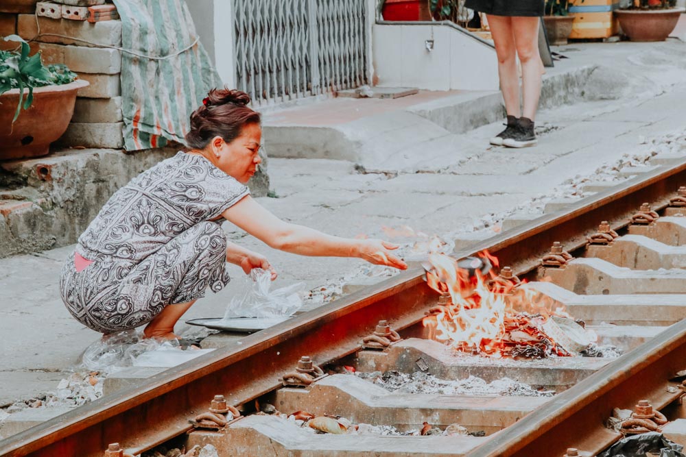 Frau verbrennt Joss Papers auf den Bahngleisen der Train Street